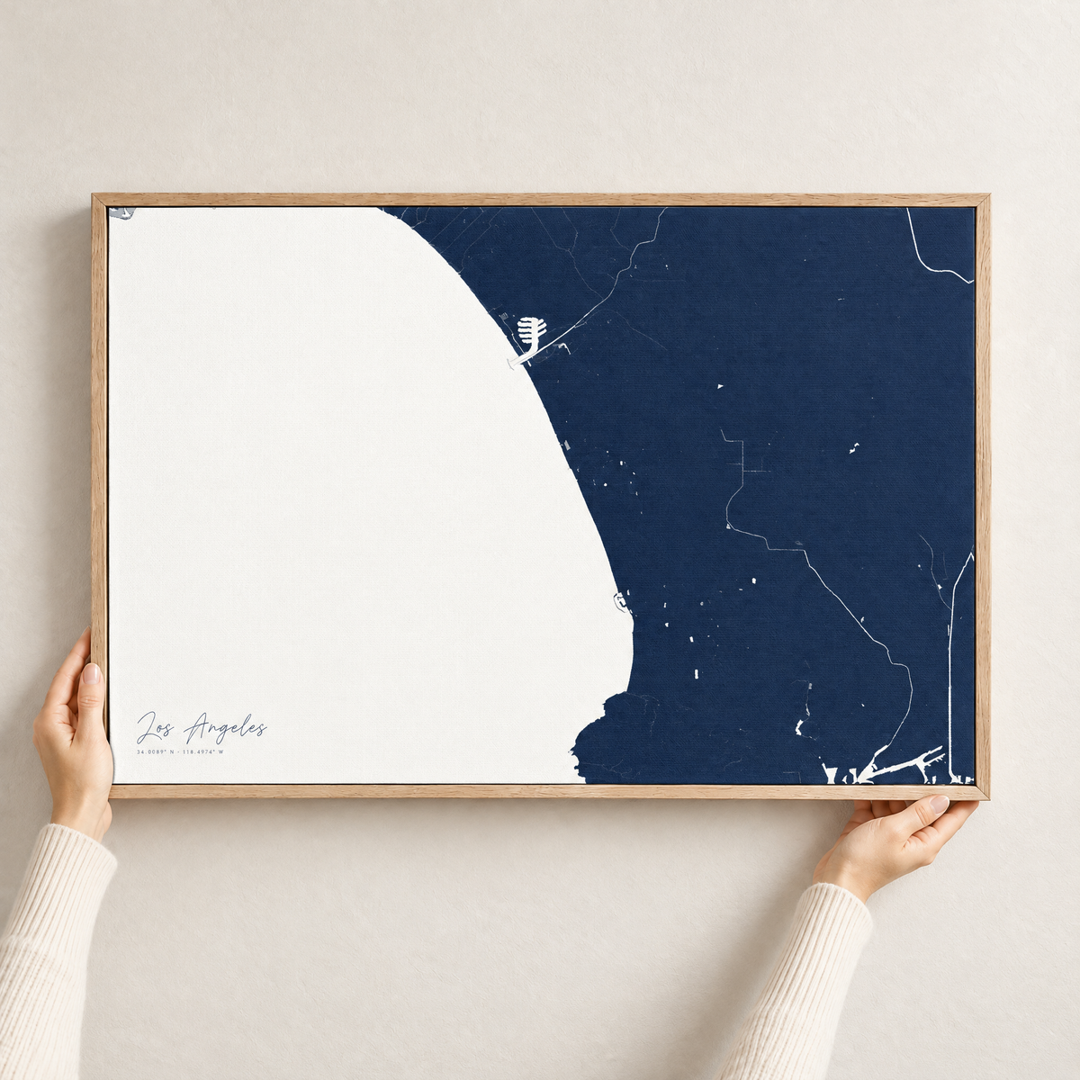 Los Angeles horizontal canvas map in Navy, hands holding an oak-framed canvas