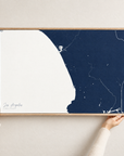Los Angeles horizontal canvas map in Navy, hands holding an oak-framed canvas
