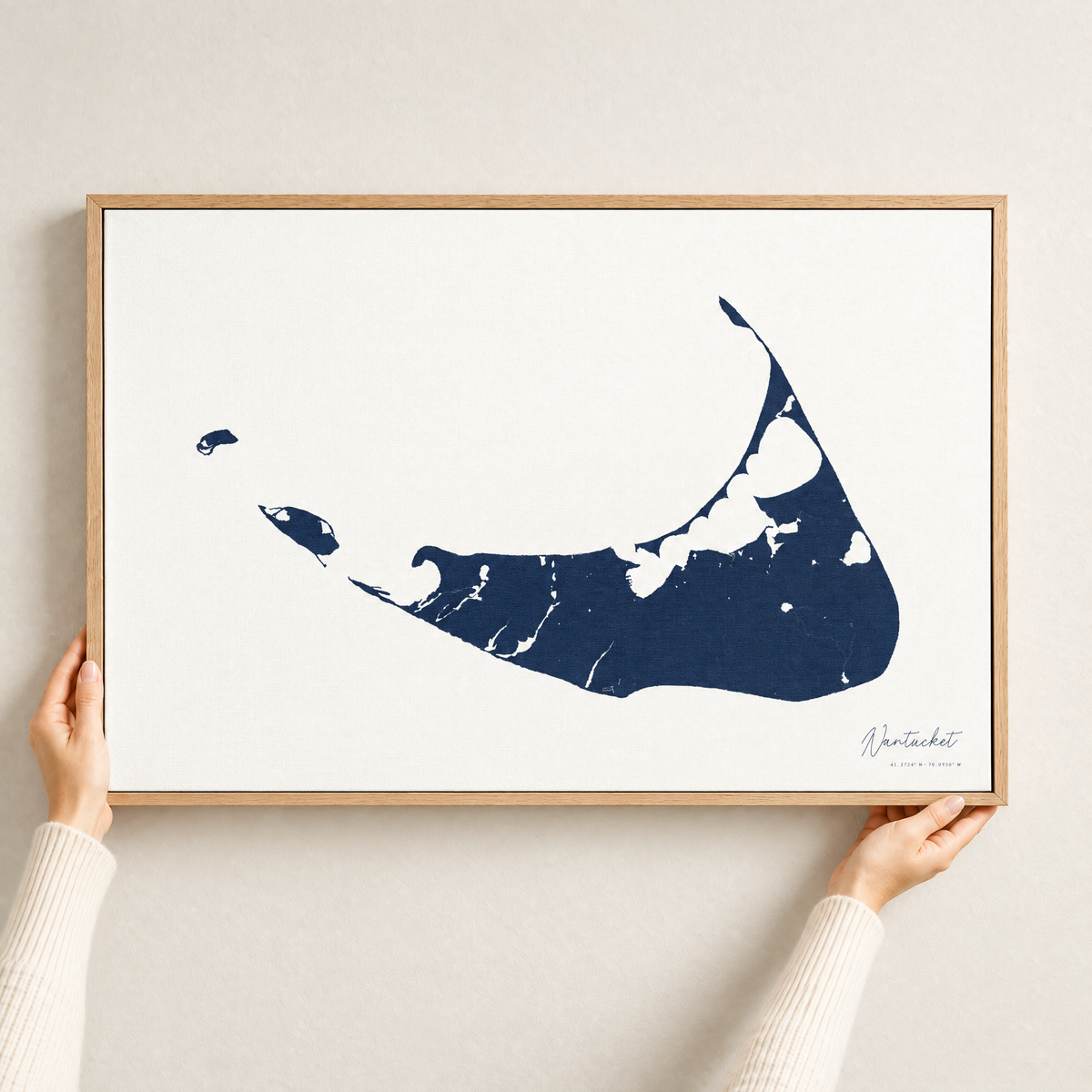 Nantucket horizontal canvas map in Navy, hands holding an oak-framed canvas