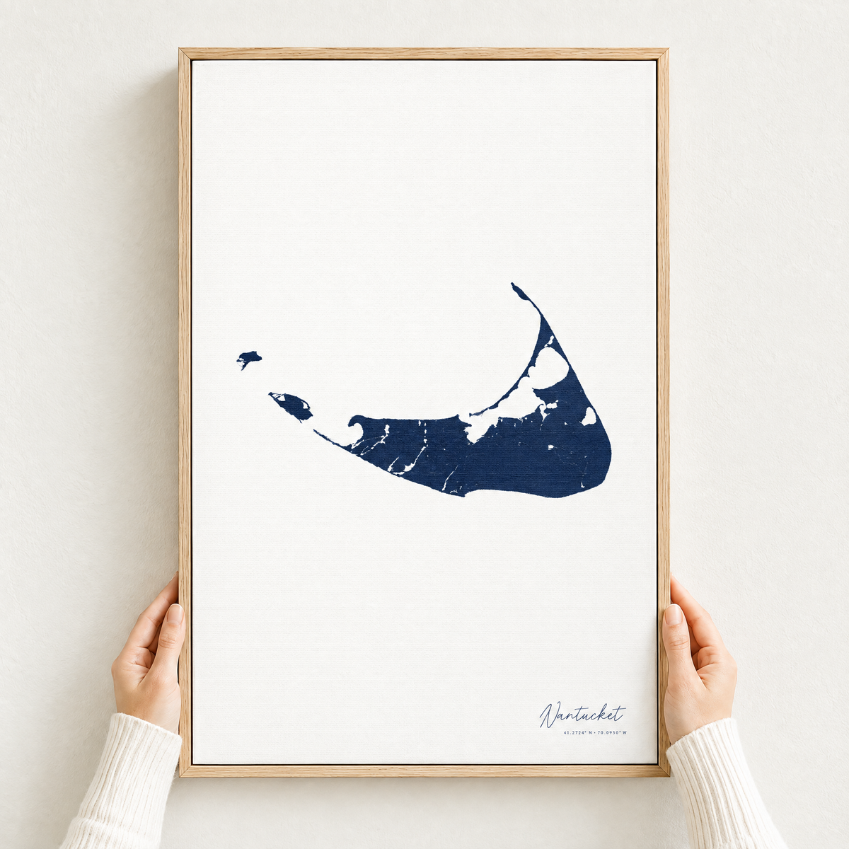 Nantucket vertical canvas map in Navy, hands holding an oak-framed canvas