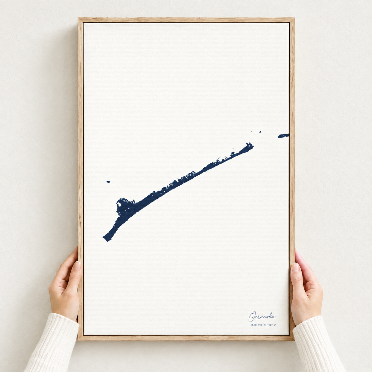 Ocracoke vertical canvas map in Navy, hands holding an oak-framed canvas