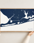 Orange Beach horizontal canvas map in Navy, hands holding an oak-framed canvas