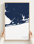 Orange Beach vertical canvas map in Navy, hands holding an oak-framed canvas