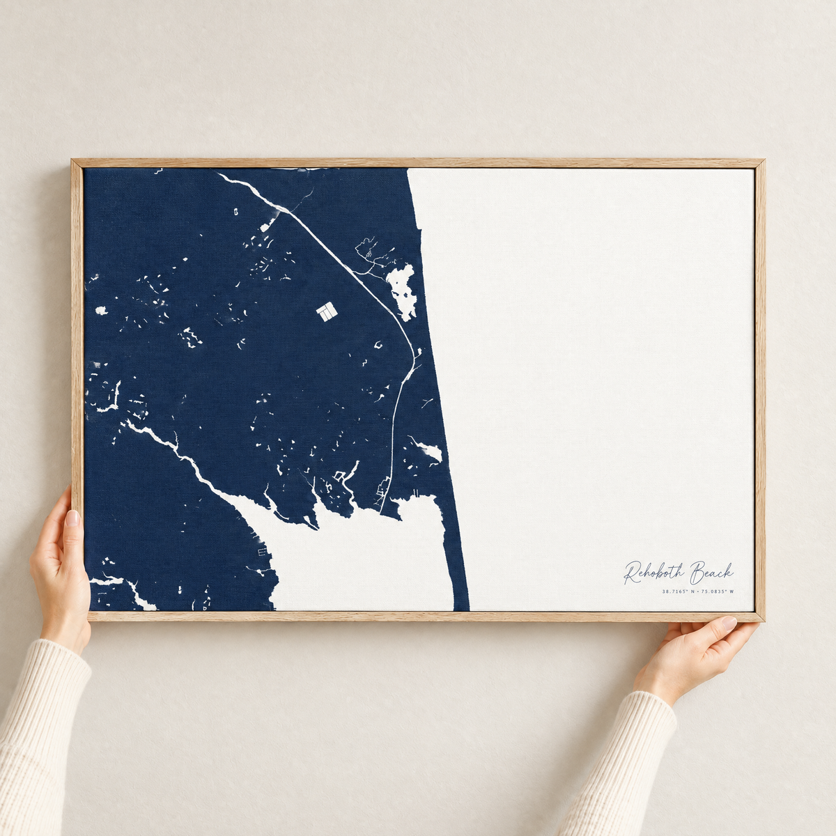 Rehoboth Beach horizontal canvas map in Navy, hands holding an oak-framed canvas