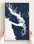 Salish Sea vertical canvas map in Navy, hands holding an oak-framed canvas