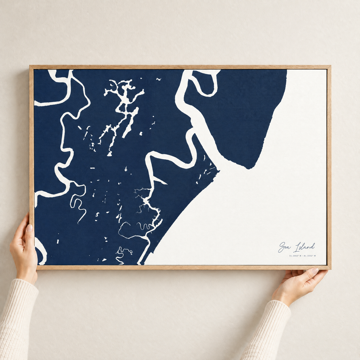 Sea Island horizontal canvas map in Navy, hands holding an oak-framed canvas