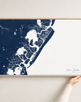 Stone Harbor horizontal canvas map in Navy, hands holding an oak-framed canvas