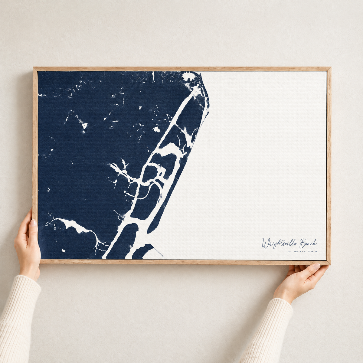 Wrightsville Beach horizontal canvas map in Navy, hands holding an oak-framed canvas