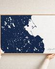 Plymouth canvas map — hands holding the canvas in an oak frame