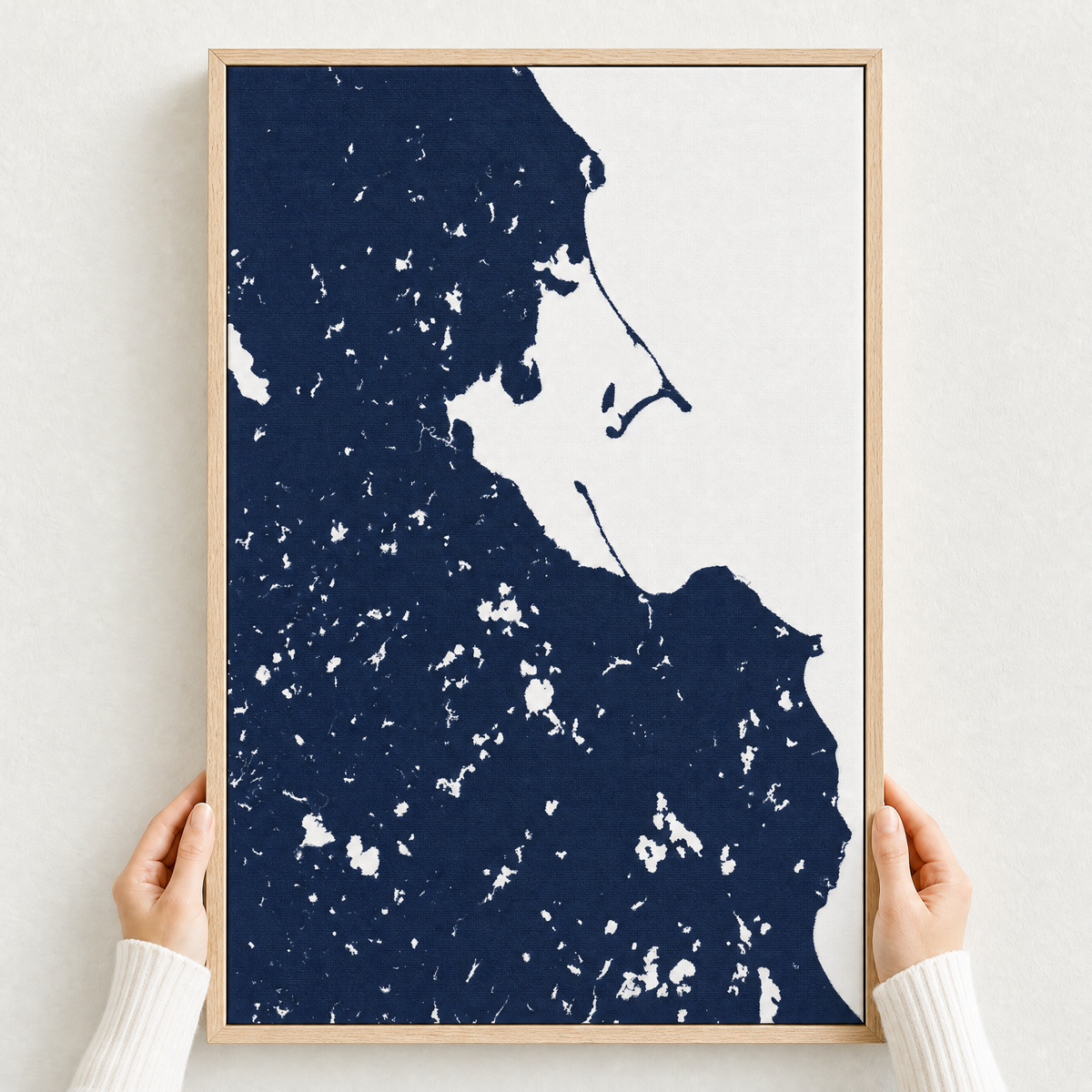 Plymouth canvas map — hands holding the canvas in an oak frame