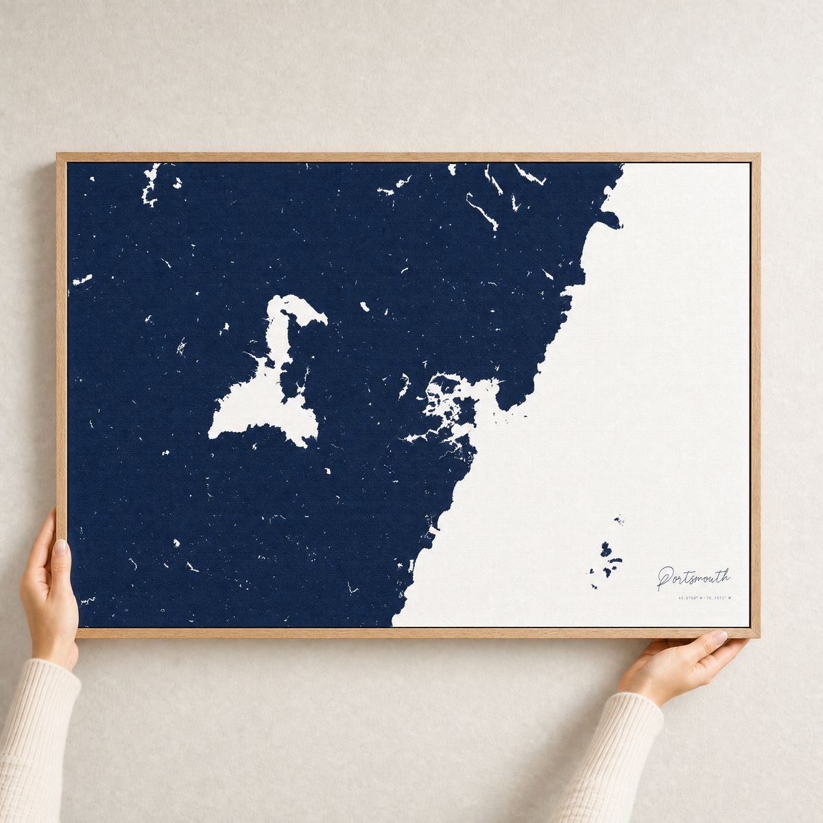 Portsmouth canvas map — hands holding the canvas in an oak frame