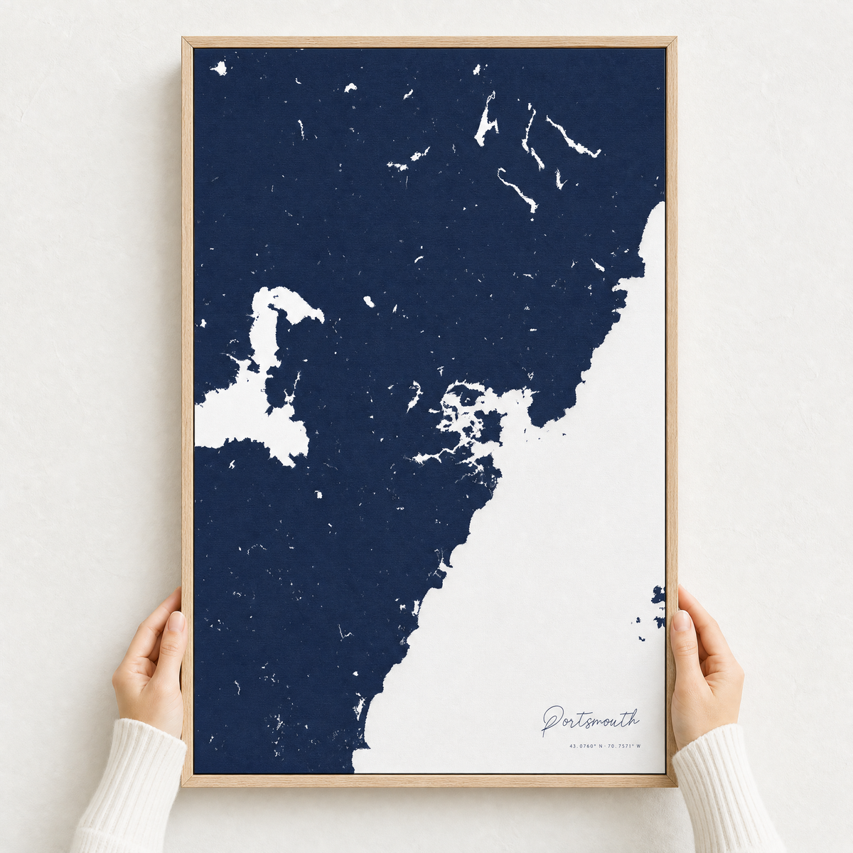 Portsmouth canvas map — hands holding the canvas in an oak frame