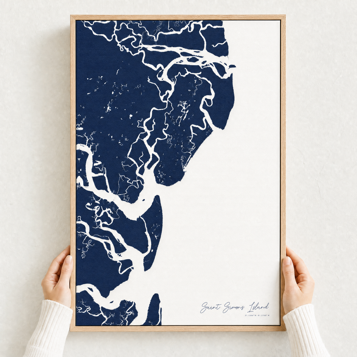 Saint Simons Island canvas map — hands holding the canvas in an oak frame