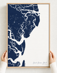 Saint Simons Island canvas map — hands holding the canvas in an oak frame