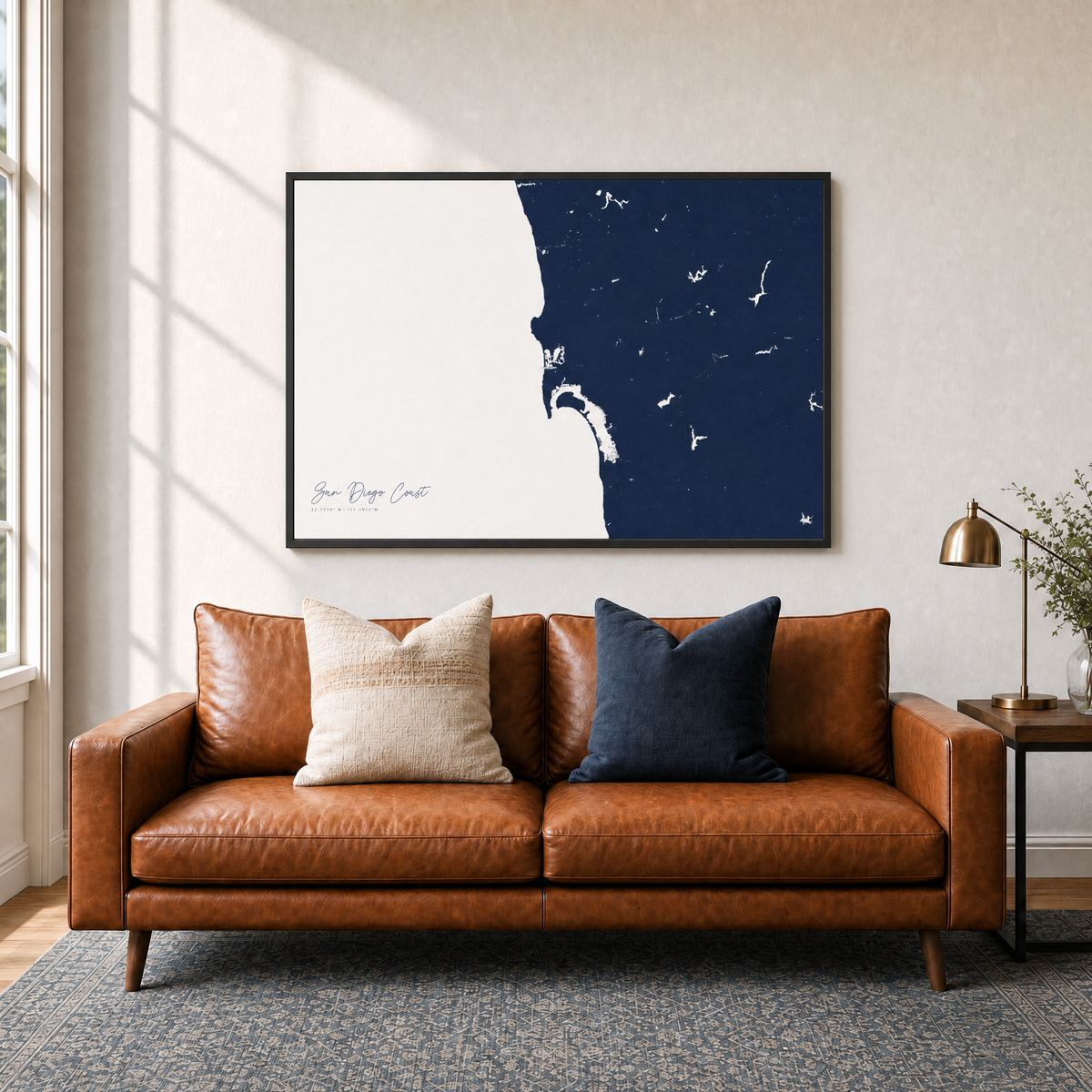 San Diego Coast canvas map — two-pillow black-frame sofa interior