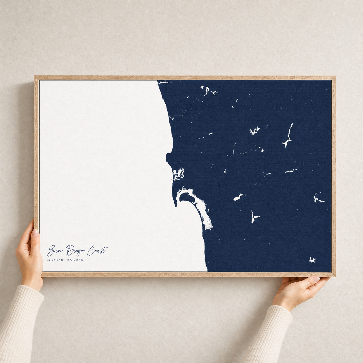 San Diego Coast canvas map — hands holding the canvas in an oak frame