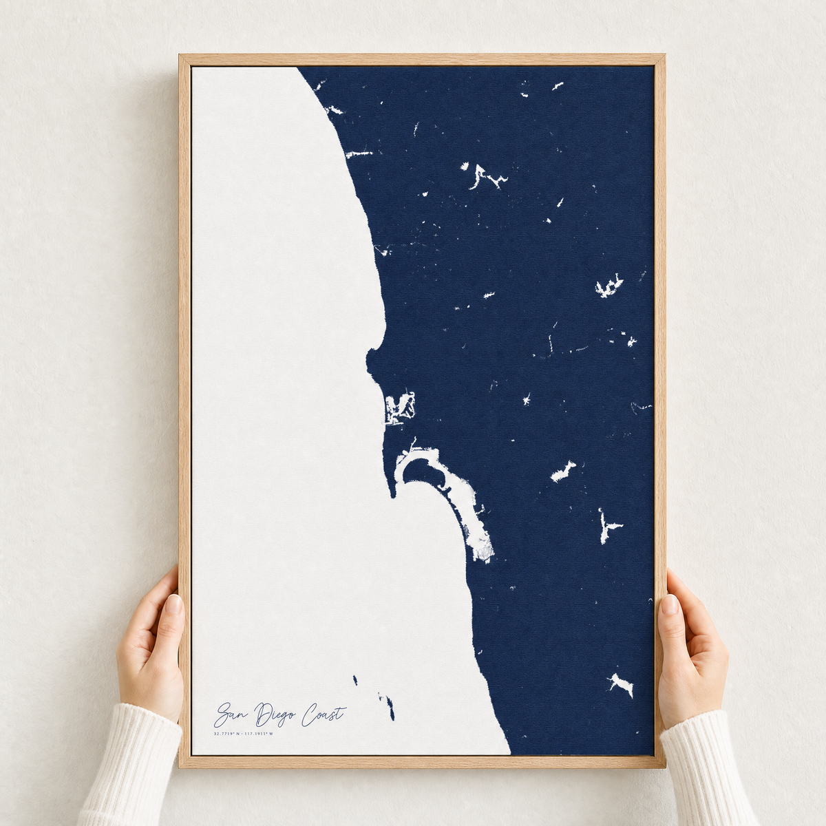 San Diego Coast canvas map — hands holding the canvas in an oak frame