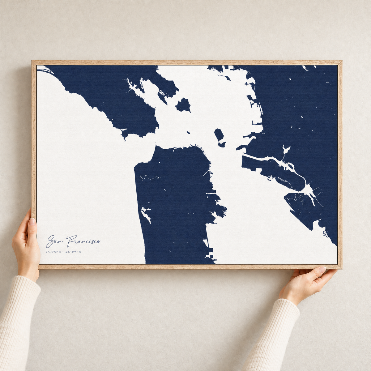 San Francisco canvas map — hands holding the canvas in an oak frame