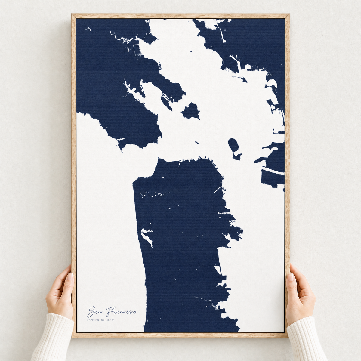 San Francisco canvas map — hands holding the canvas in an oak frame