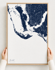 Sanibel canvas map — hands holding the canvas in an oak frame