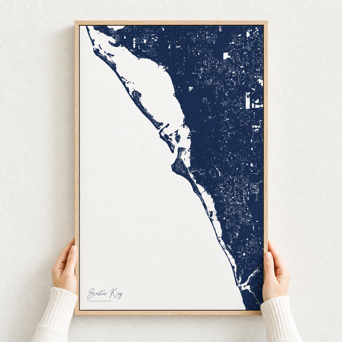 Siesta Key canvas map — hands holding the canvas in an oak frame