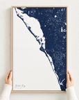 Siesta Key canvas map — hands holding the canvas in an oak frame