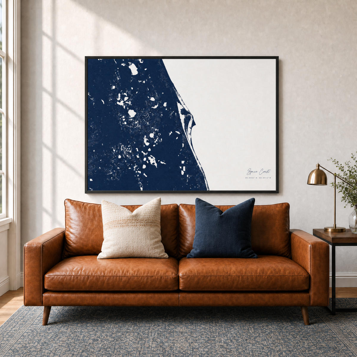 Space Coast canvas map — two-pillow black-frame sofa interior