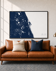 Space Coast canvas map — two-pillow black-frame sofa interior
