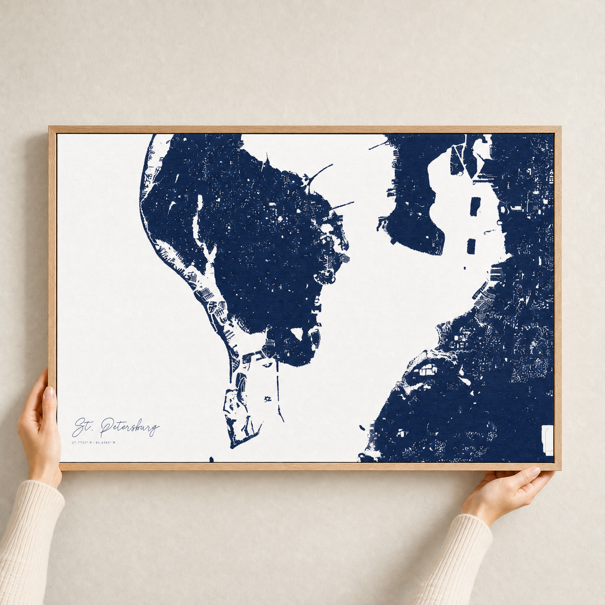 St. Petersburg canvas map — hands holding the canvas in an oak frame