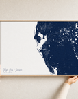 Tampa Bay / Sarasota canvas map — hands holding the canvas in an oak frame