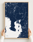 Tampa canvas map — hands holding the canvas in an oak frame