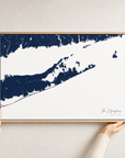 The Hamptons canvas map — hands holding the canvas in an oak frame