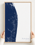 The Palm Beaches canvas map — hands holding the canvas in an oak frame