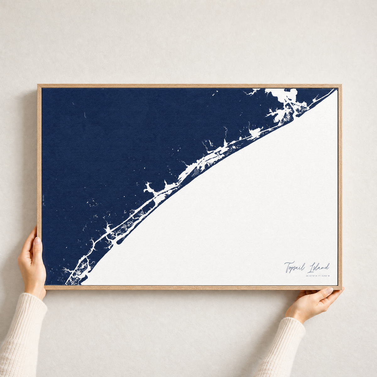 Topsail Island canvas map — hands holding the canvas in an oak frame