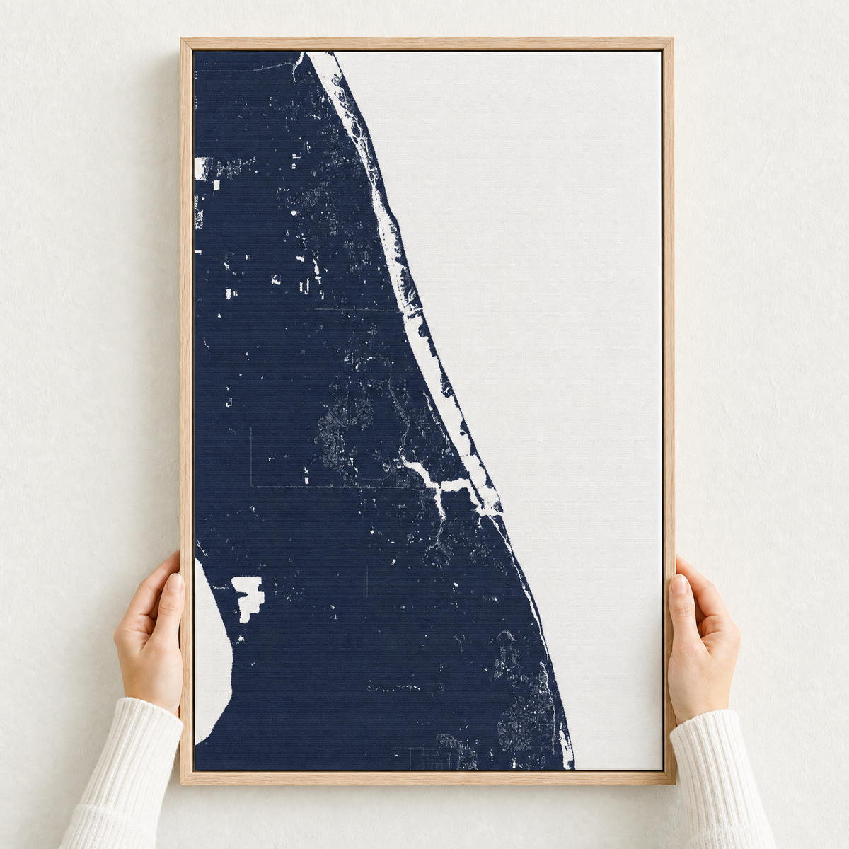 Treasure Coast canvas map — hands holding the canvas in an oak frame